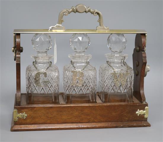 A Betjemann three decanter tantalus, with labels